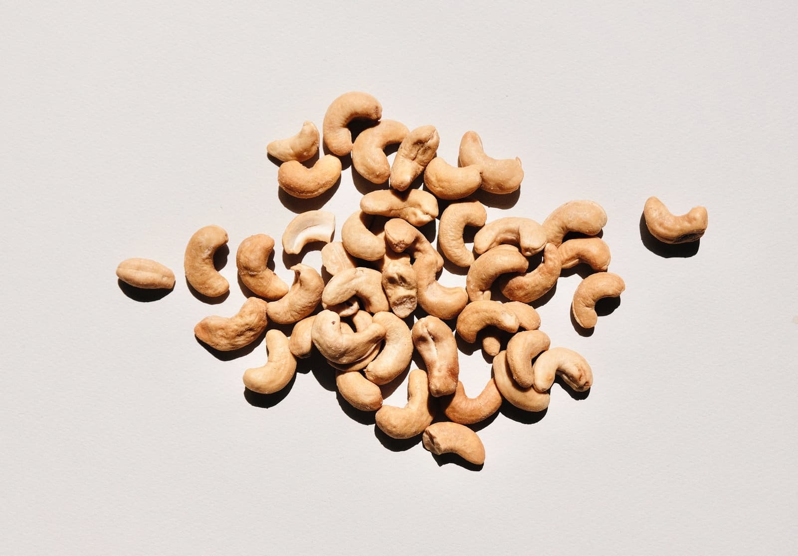 handful of cashew nuts on white surface