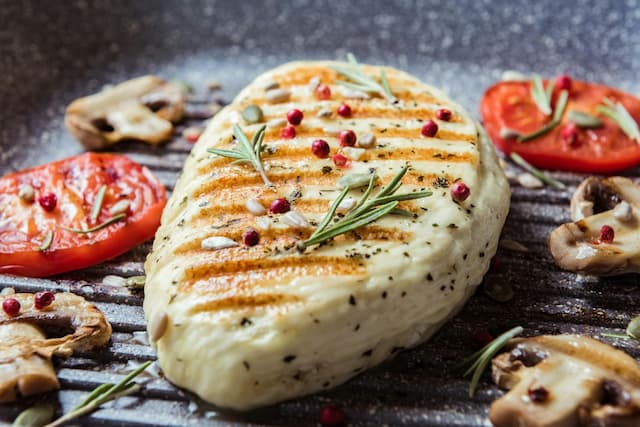 fried-halloumi-cheese-with-red-tomatoes-rosemary-champignons-close-up-balanced-food-cooking-grill-pan