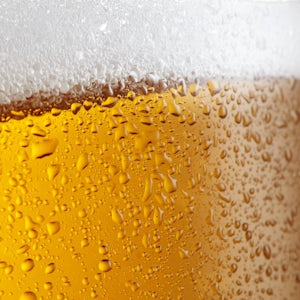 close up of beer glass with foaming head