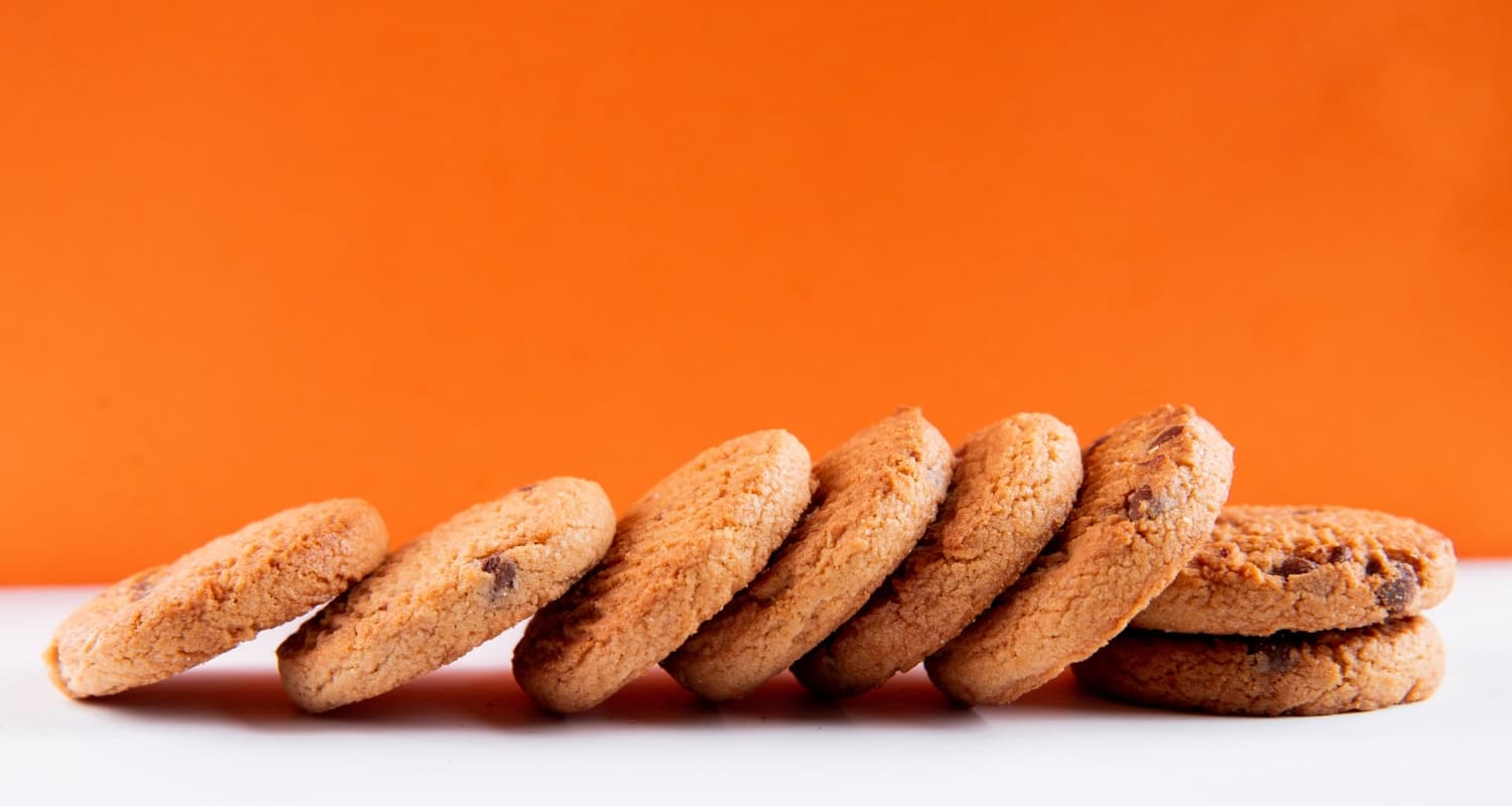 top-view-oatmeal-cookies-with-chocolate-white-orange-background
