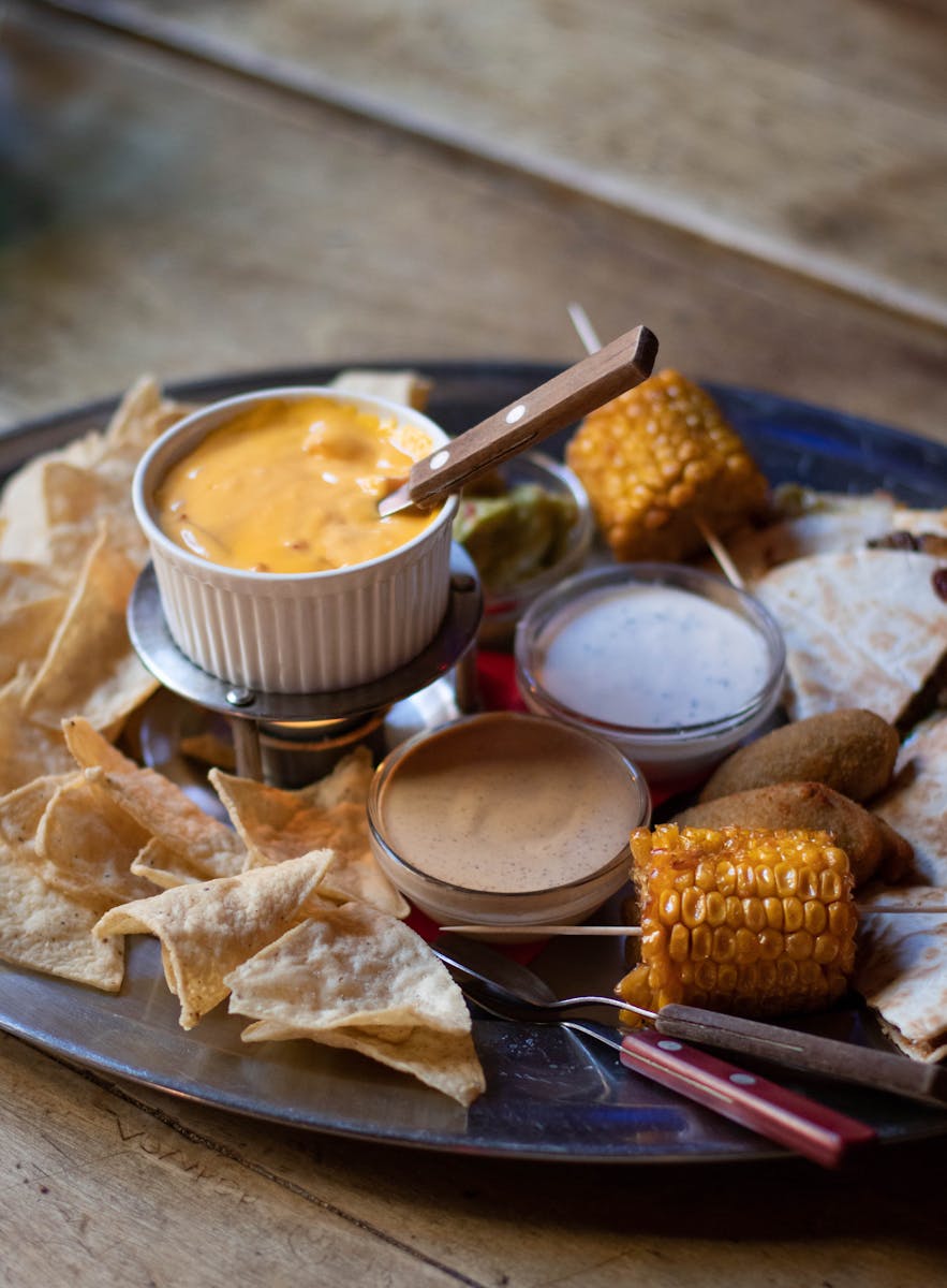 Delectable Mexican-style platter with assorted dips, nachos, quesadillas, and grilled corn.