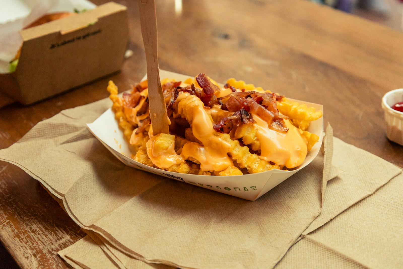 Indulge in crispy crinkle-cut fries topped with gooey cheese sauce and savory bacon.