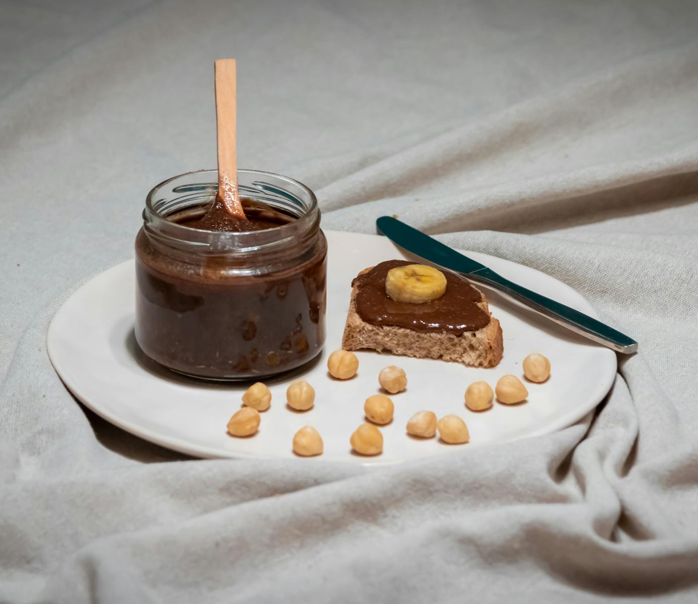 Chocolate hazelnut spread with banana on bread slice, perfect for breakfast.