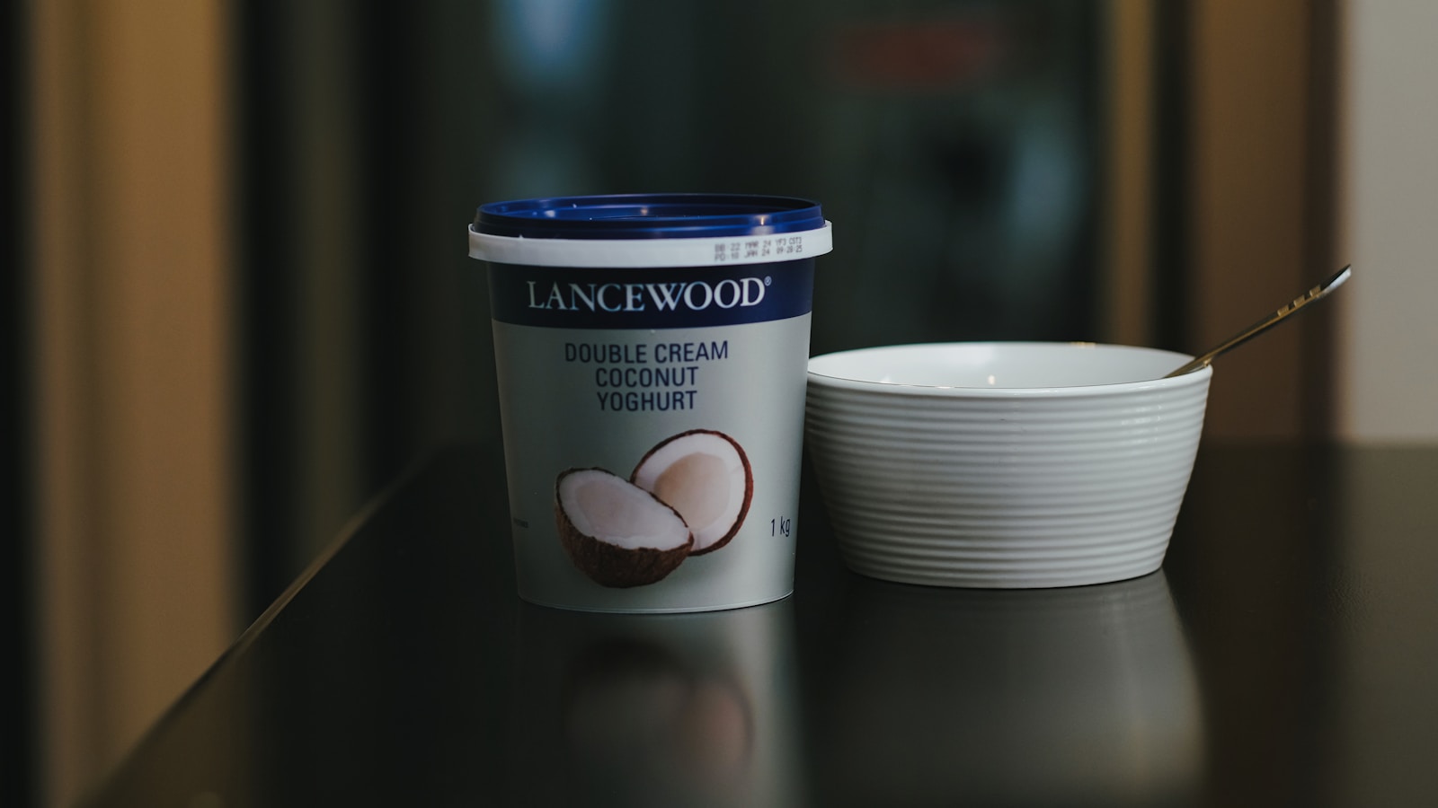 a cup of coffee next to a container of ice cream