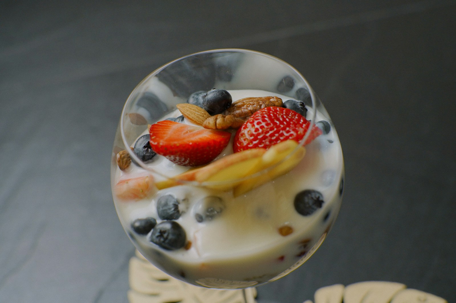 a glass of yogurt with fruit on top