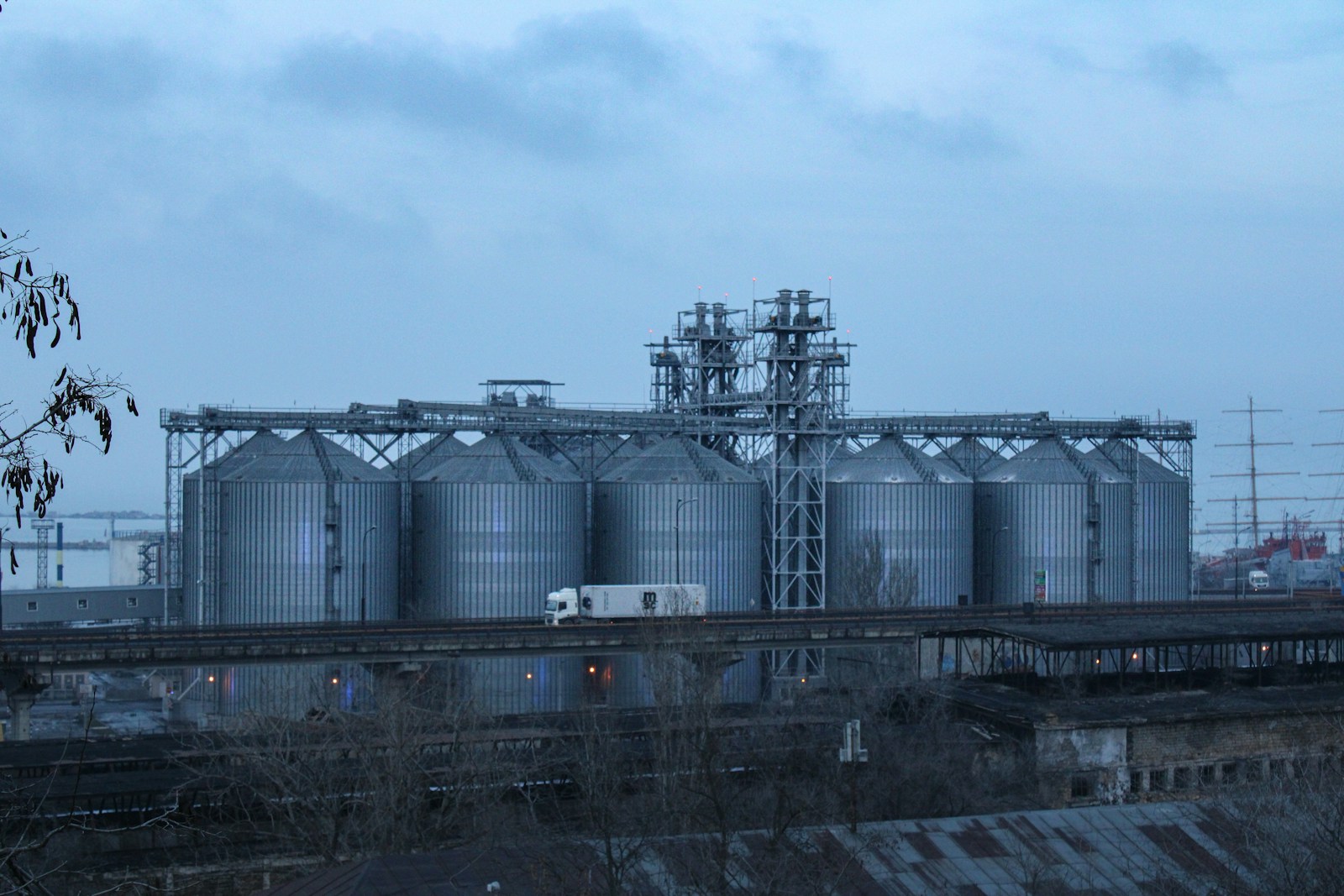 a train traveling past a large industrial building